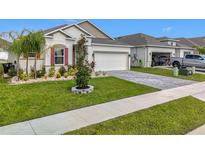 Charming single-story home features a well-manicured lawn, paver driveway, and lush landscaping at 6612 Tempo Way, Mascotte, FL 34753