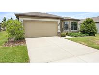 Home exterior showing a two-car garage, landscaped yard, and concrete driveway at 9478 Sw 52Nd Loop, Ocala, FL 34481