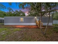 Charming single-story home featuring gray siding, a wooden entry staircase, and a well-kept front yard at 221 Se 167Th Ct, Silver Springs, FL 34488