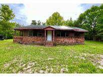 Quaint brick and wood home featuring a cozy front porch and a spacious yard at 3682 Jack Pine Ln, Ormond Beach, FL 32174