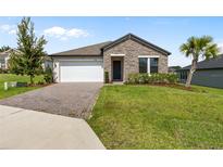 Charming single-Gathering home featuring stone accents, a two-car garage, and a well-maintained front yard at 3940 Se 5Th Ave, Ocala, FL 34480