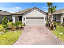 Charming single-story home featuring a two-car garage, well-maintained landscaping, and a brick driveway at 1192 Via Galuppi St, Kissimmee, FL 34759