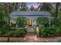 Charming home featuring mature landscaping, brick path, and a welcoming front porch at 5881 Avenue H, Mc Intosh, FL 32664