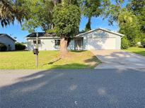 Charming single-story home with a well-manicured lawn and an attached two-car garage at 11027 Sw 75Th Ave, Ocala, FL 34476