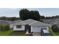 Charming single-story home featuring a well-maintained lawn and an attached one car garage at 32932 Crooked Oaks Ln, Leesburg, FL 34748