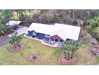 Blue house with white roof and landscaping, aerial view at 112 Reedy Creek Dr, Frostproof, FL 33843