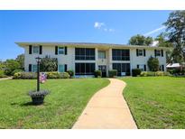 Well-maintained two-story condo building featuring a lush lawn and inviting walkway, with black shutters at 711 Springer Dr # 2, Lake Wales, FL 33853