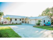 Charming single-story home with a metal roof, spacious driveway, and lush green lawn at 1800 N Scenic Hwy, Babson Park, FL 33827