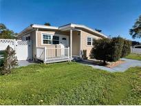 Charming single-story home featuring a cozy front porch, well-maintained lawn, and a beautiful exterior paint scheme at 1831 Richmond Rd, Lakeland, FL 33803