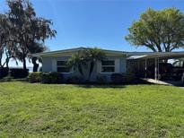 Charming single-story home with a well-maintained lawn and a convenient carport at 2263 Lake Reedy N Blvd, Frostproof, FL 33843