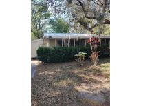 Quaint single-story home featuring mature landscaping in a serene setting with ample shade and a metal roof at 342 Hibiscus Dr, Lake Wales, Fl. 33898, FL 33898