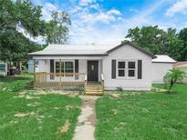 Inviting one-story home boasts a classic facade, front porch, and metal roof at 111 D St, Frostproof, FL 33843