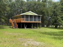 Charming home featuring a screened porch, elevated design, and a tranquil wooded setting at 1885 Pfundstein Rd, Babson Park, FL 33827