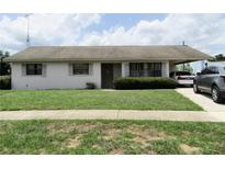 Charming single-story home featuring a well-maintained lawn and covered parking at 405 S Shore Dr, Eagle Lake, FL 33839
