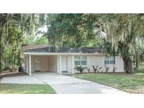 Charming single-story home featuring a covered parking area and mature trees draped with Spanish moss at 4725 Kayworth Rd, Lake Wales, FL 33898