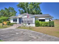 Charming single-story home featuring a well-maintained lawn, mature trees, and an American flag at 509 N Scenic Hwy, Frostproof, FL 33843