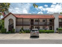 A cozy condo showcases a red tile roof and a charming, well-maintained facade with ample parking at 6201 Country Club Dr # 21, Lake Wales, FL 33898