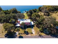 Expansive aerial view of a waterfront home with a dock and mature landscaping near a tranquil lake at 7254 Wisteria Ln, Lake Wales, FL 33898