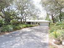 Charming single-story home with a driveway and a lush, landscaped front yard featuring mature trees at 882 Redwood Way, Lake Wales, FL 33898