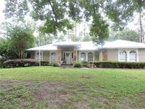 Charming single-story home featuring stone accents, arched windows and a well-manicured lawn and landscaping at 9365 Lemon Dr, Lake Wales, FL 33898