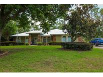 Charming ranch-style home with a lush green lawn and mature trees, offering a serene and inviting curb appeal at 9365 Lemon Dr, Lake Wales, FL 33898