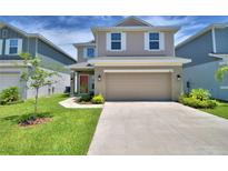 Charming two-story home with a well-manicured lawn, large driveway, and an inviting red door at 1417 Leamington Ln, Winter Haven, FL 33884