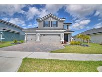 Stunning two-story home featuring a three-car garage and lush landscaping at 4646 Grandview Glen Dr, Auburndale, FL 33823