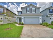 Charming two-story home with a two-car garage, green lawn, and neatly landscaped front yard at 1484 Leamington Ln, Winter Haven, FL 33884
