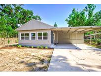 Charming single-story home featuring a carport, neutral paint, and landscaping with sunny curb appeal at 318 Senate St, Auburndale, FL 33823
