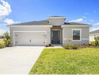 Inviting single-story home with a well-manicured lawn and a two-car garage at 2101 Summerlake Dr, Auburndale, FL 33823