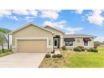 Charming single-story home featuring a well-manicured lawn and a two-car garage at 5879 Swallow Dr, Lakeland, FL 33809