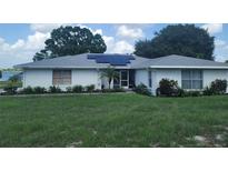 Charming single-story home featuring a white brick exterior, solar panels, well-maintained landscaping and inviting front porch at 152 Audubon Ct, Winter Haven, FL 33884