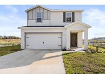 Two-story house with white siding, gray accents, and a two-car garage at 5440 Se 127Th Ln, Belleview, FL 34420