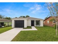 Charming single Gathering home with a black garage door and front door, surrounded by a green lawn at 1918 Dr Martin L King Jr Way, Haines City, FL 33844