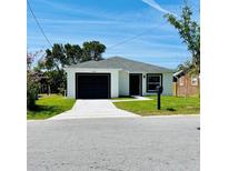 Charming single story home with a black garage door and well maintained lawn at 1918 Dr Martin L King Jr Way, Haines City, FL 33844