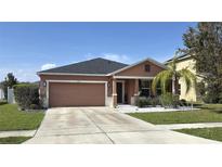 Charming single Gathering home with neutral tones, well maintained lawn, and an attached two-car garage at 1109 Brenton Manor Dr, Winter Haven, FL 33881