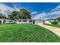 Charming single-story home with a well-manicured lawn and attached garage, set against a bright blue sky at 2350 E Washington St, Bartow, FL 33830