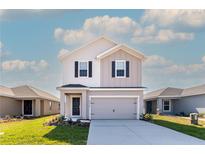 Charming two-story home featuring a gray facade, black shutters, and a two-car garage at 2214 Oldham Ct, Haines City, FL 33844
