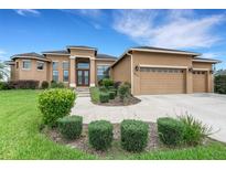 Stunning home features a lush lawn, manicured landscaping, and a three-car garage, offering curb appeal at 5074 Shore Side Dr, Lakeland, FL 33812