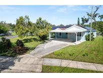 Charming single-story home featuring a covered carport and well-maintained landscaping with solar panels at 1220 Woodland Ave, Lakeland, FL 33801
