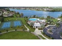 Aerial view of a community center with a pool, tennis courts, parking, and access to a scenic lake at 5514 Maggiore Blvd, Lakeland, FL 33805
