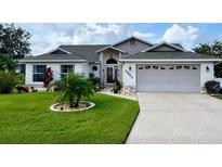 Charming single-story home featuring lush green lawn, mature landscaping, and a two-car garage, with an inviting facade at 5982 Crane Dr, Lakeland, FL 33809