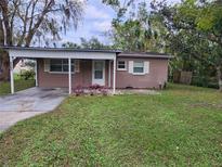 View of the front of a house with a carport, garden, and well-maintained lawn at 3203 Decatur Ave, Lakeland, FL 33805