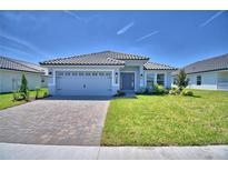 Beautiful single-story home featuring a stone driveway, gray siding, and a well-manicured lawn at 4639 Grandview Glen Dr, Auburndale, FL 33823
