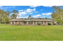 Charming brick home with lush green lawn and well-maintained landscaping at 9240 Moore Rd, Lakeland, FL 33809