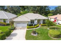 Single-story home with tile roof, landscaped yard, and a two-car garage at 202 Golf Aire Blvd, Winter Haven, FL 33884