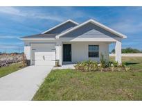 Charming single-Gathering home featuring a tidy lawn, a single-car garage, and a welcoming front porch at 428 Ituna Cir, Winter Haven, FL 33881