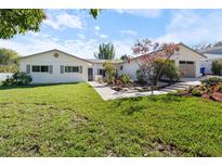 Charming single-story home with a lush green lawn, fresh landscaping, and an attached two-car garage at 1323 Valley E Hl, Lakeland, FL 33813