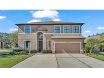 Two-story house with a two-car garage and landscaped lawn at 505 Oak Landing Blvd, Mulberry, FL 33860