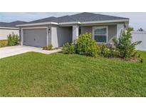 Single-story house with gray siding, gray garage door, and well-manicured lawn at 1225 Third Ct, Eagle Lake, FL 33839